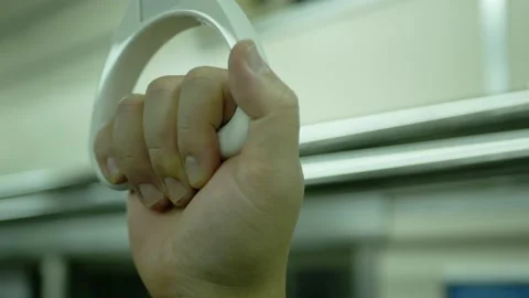 Close up of Hands holding handrail or grip straps in metro train, passenger.. Stock Footage 229484903