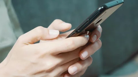 Close-up of hands holding her phone and scrolling on social media, standing Stock-Footage 336249356