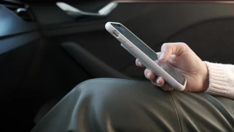 Close-up of hands holding her phone and scrolling on social media, Sitting in a Stock-Footage 336249488
