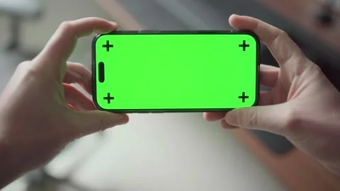 Close-up of hands holding an iPhone 16 Pro with a green screen for display Stock Footage 295131637