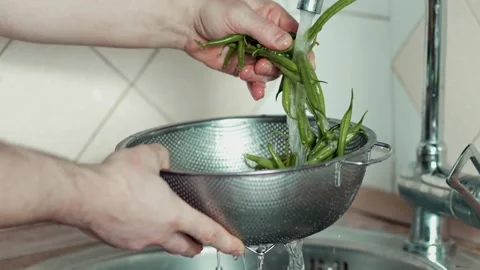 Close up of hands holding a metal colander with fresh green beans Video stock 343555577