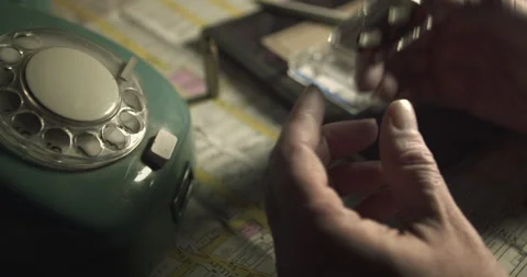 Close Up of Hands Holding Micro Cassette Tape Over Crime Desk Stock Footage 331054703