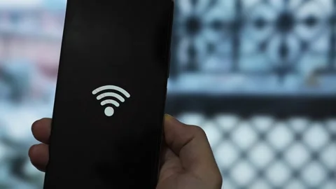 Close-up of hands holding a mobile phone showing a Wi-Fi error symbol agains Stock Footage 340510023