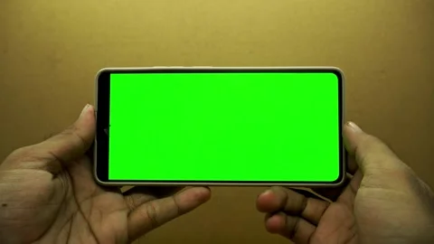 Close up of hands holding modern smartphone with empty blank green screen d.. Stock Footage 345131307