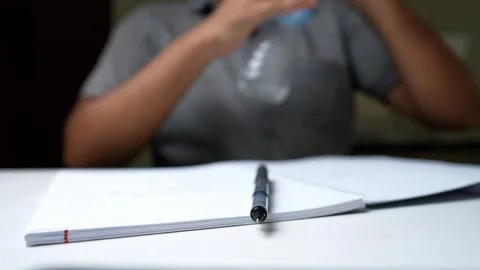 Close-Up of Hands Holding Pen Over Notebook Stock Footage 320725052