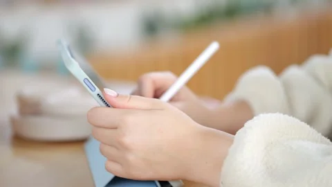 Close-up of hands holding phone and stylus over tablet Video stock 346237632