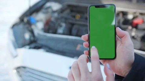 Close up hands holding phone with vertical green screen in the background white Stock Footage 105603097