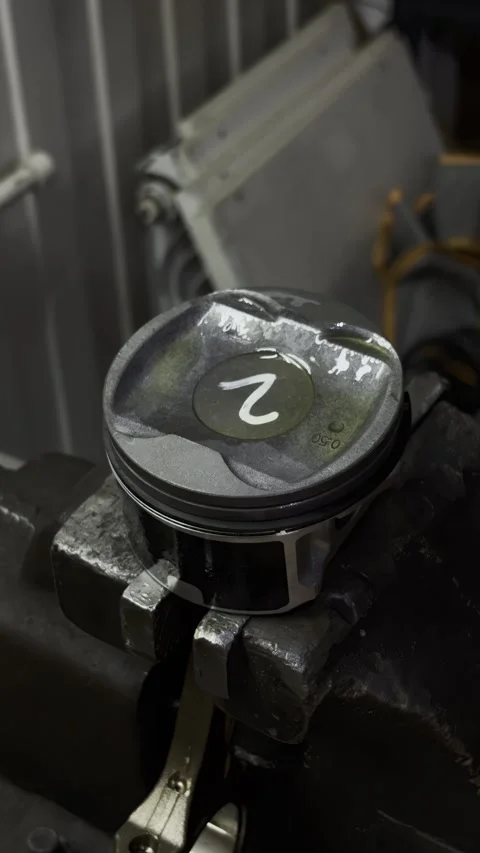 Close up of hands holding a piston with number two. Stock Footage 332064827