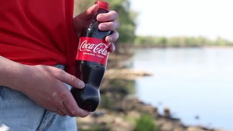 Close-up of hands holding a plastic bottle of Coca-Cola Original Taste Stock-Footage 334792428