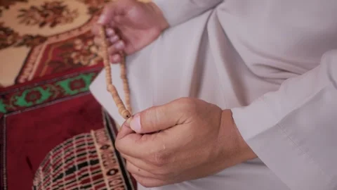 Close up of hands holding prayer beads in a mosque Stock Footage 323164323
