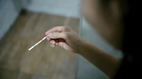 Close-up of hands holding pregnancy test. Female hands holding pregnancy test Stock Footage 265934291