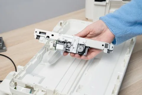 Close-up of hands holding a printer scanner carriage removed from a flatbed s Stock Photos