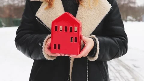 Close up of hands holding red house on nature winter background 스톡 동영상 262366833