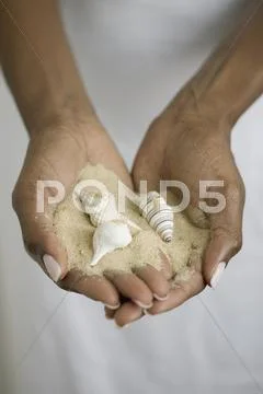Close up of hands holding sand and seashells Stock Photos
