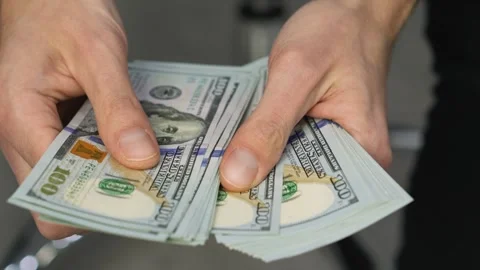 Close up of hands holding several US dollar bills, symbolizing financial success Stock Footage 341037602