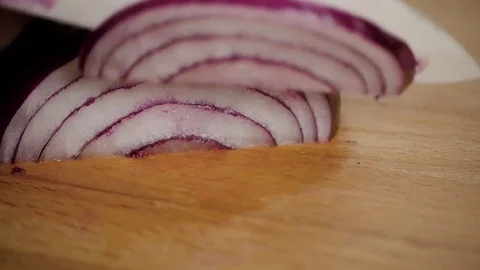 Close up hands holding sharp knife and chopping fresh red onion on kitchen with Stock-Footage 73670350