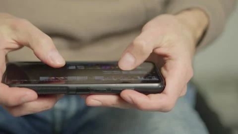 Close up of hands holding a smartphone and interacting with the touchscreen 库存影片 341032264