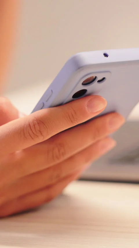 Close up hands holding smartphone on bed with soft light and cozy home mood 스톡 동영상 324727515