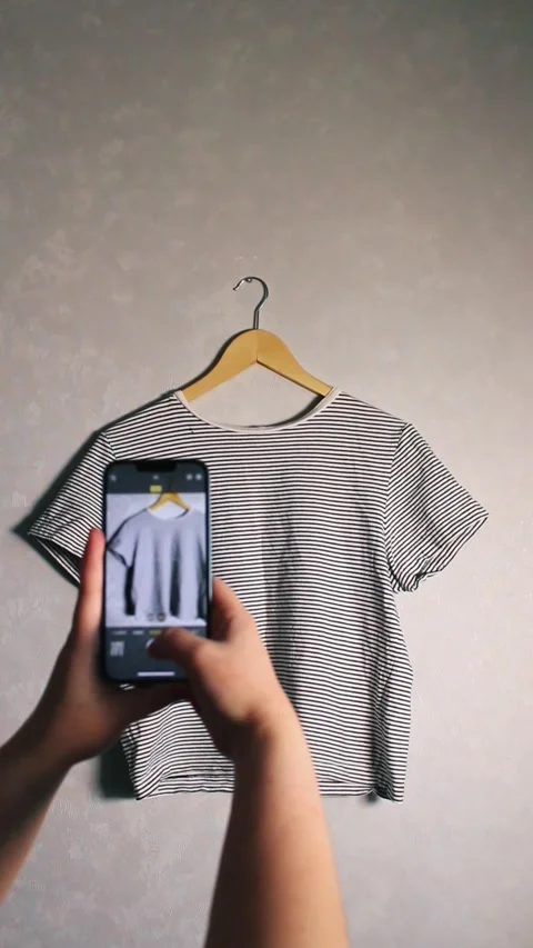 Close up of hands holding smartphone camera capturing old clothes items Stock Footage 311893667