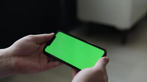 Close-up of hands holding a smartphone with a green screen display Stock Footage 339213282