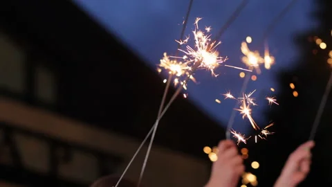 Close up hands holding sparklers group of friends celebrating waving sparkler Video stock 196005686