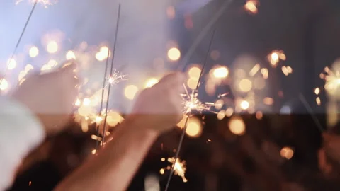 Close up hands holding sparklers group of friends celebrating waving sparkler Stock Footage 196006718