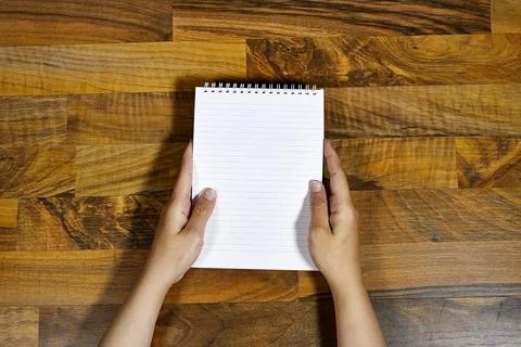 Close-Up of Hands Holding Spiral Notebook on Wooden Table Stock Photos
