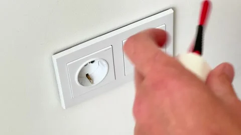 Close-Up of Hands Holding Tangled Red Cable in Front of Wall Power Outlets Stock Footage 345640266