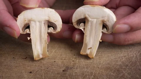 Close-Up of Hands Holding Two Slices of Fresh Mushroom, Edible Raw Mushroom 動画素材 332821167