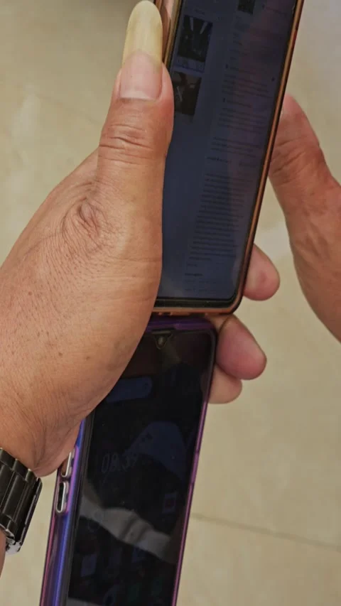 Close Up Hands Holding Two Smartphones Scrolling Webpage With Long Thumbnail Stock Footage 340001482