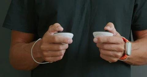 Close-up of hands holding white controllers, plays in virtual reality. Stock Footage 256184692
