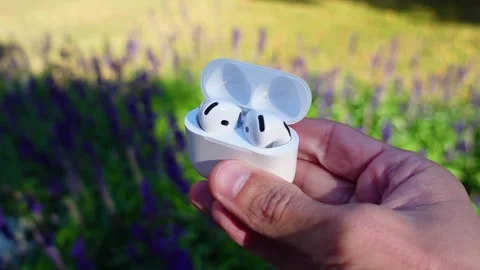 Close-up of Hands Holding Wireless Earbuds Outdoors Stock Footage 319832198