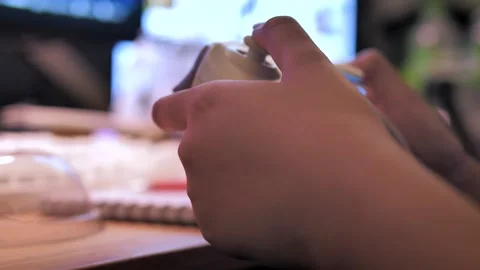 Close-Up of Hands Holding a Wireless Game Controller While Playing Video Game Stock Footage 344915188