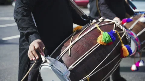 Close-up hands of Indian man playing Indianmusical instrument Dhol drum using Stock Footage 219948241