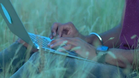 Close-up, Hands of an Indian Paren Sitting on the Grass Typing Text on the Stock Footage 92032309