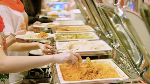 Close-up of hands of Indians taking food from a self service buffet line. Vídeos de archivo 300347724