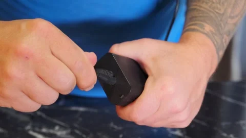 Close-up of hands inserting cable into drone unit port, preparing device for Video stock 333649503