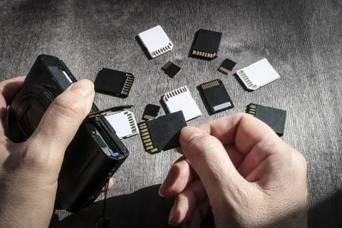 Close-up of hands inserting a memory card into the camera's memory slot, wi.. Stock Photos