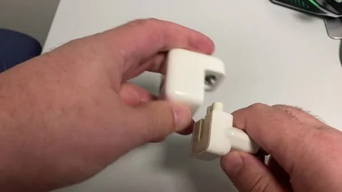 A close-up of hands inserting a small, white electrical plug into a corresp.. Stock Footage 323001224