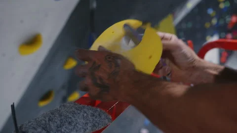 Close-up of hands installing a climbing hold on an indoor climbing wall Stock Footage 277149547