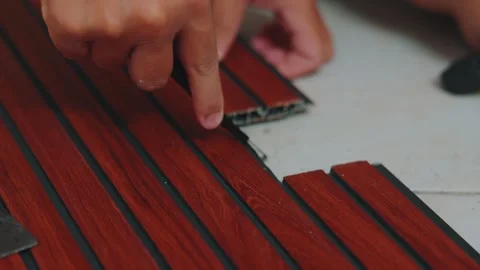 Close-up of Hands Installing Interlocking Wood Pattern Floor Panels 動画素材 333321237