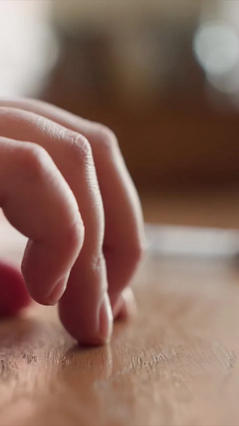 Close up of hands interacting with wooden surface in soft indoor lighting Stock Footage 348181719