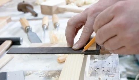 Close-up of hands of a joinery while measuring and marking the wood Stock Photos