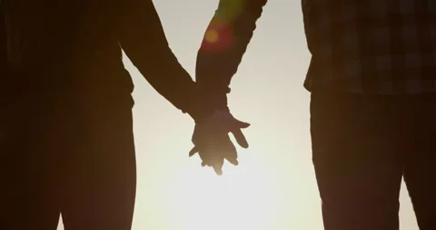 Close-up of hands joining together with sunlight flare in the background Stock Footage 195246311