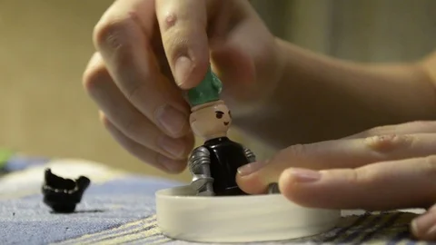 Close-up of the hands of a kid playing with a plastic toy doll Stock Footage 102416106