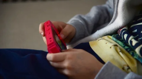 Close up hands of kid playing red colored handled console. Video stock 119862405