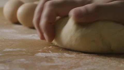 Close-Up of Hands Kneading Dough on Flour-Covered Kitchen Table Stock Footage 288813867
