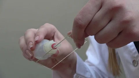 Close-up of the hands of a lab technician mixing liquid on a glass plate and the Stock Footage 88422699