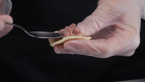 Close-up of hands in latex gloves making dumplings. Stock Footage 308521172