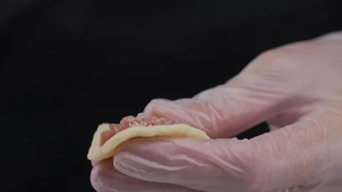 Close-up of hands in latex gloves making dumplings. Stock Footage 310580834